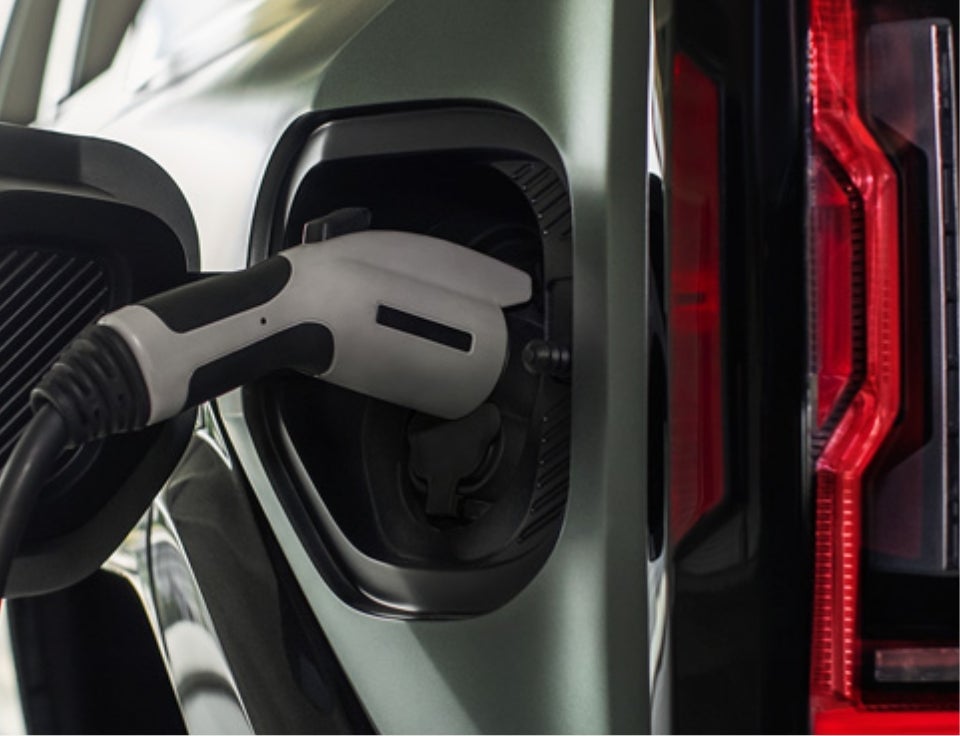 Close up of charging port with charger plugged in on a GMC Hummer EV SUV - Sudbay GMC in Gloucester MA